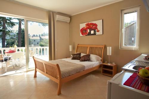 a bedroom with a bed and a balcony at Apartments Bella Vista in Kamenari