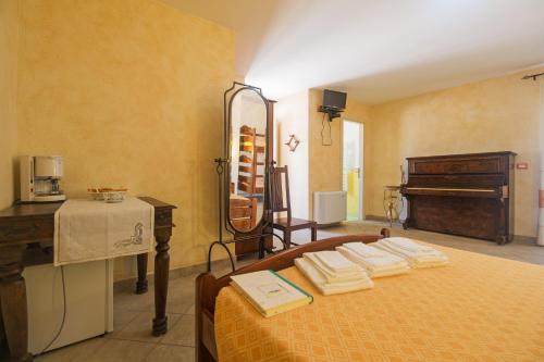 a bedroom with a bed with a mirror and a piano at Melalidone in Orosei