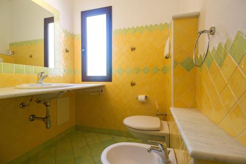 a bathroom with a toilet and a sink and a mirror at Melalidone in Orosei