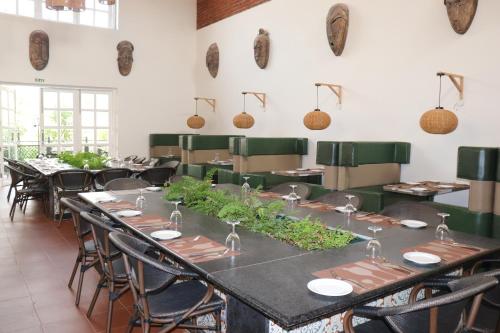 a dining room with long tables and chairs at Swosti Chilika Resort in Kānāipur