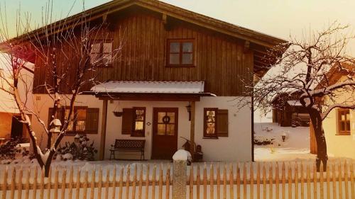 a wooden house with a fence in front of it at Ferienhaus Hornauer in Obertraubenbach