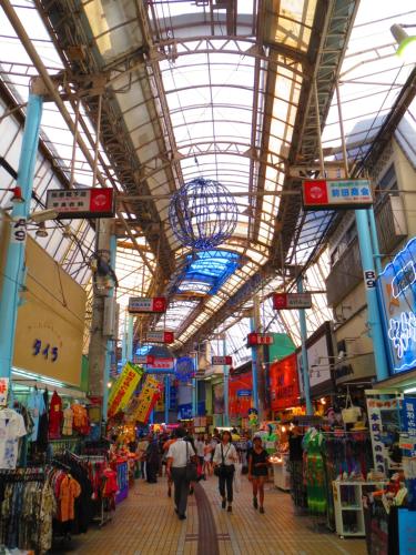 a market with people walking through a building at Stella Resort in Naha