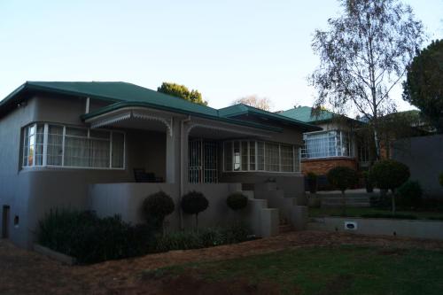 a white house with a green roof at Westmoreland Lodge in Johannesburg