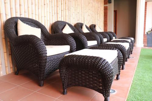 a row of wicker chairs sitting on a patio at Swosti Chilika Resort in Kānāipur