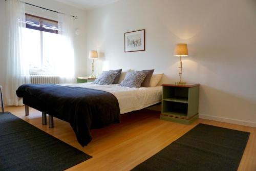 a bedroom with a bed with a table and a window at Gylleby Vandrarhem in Sunne