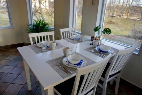 a white dining room table with white chairs and a white table and chairsktop at Gylleby Vandrarhem in Sunne
