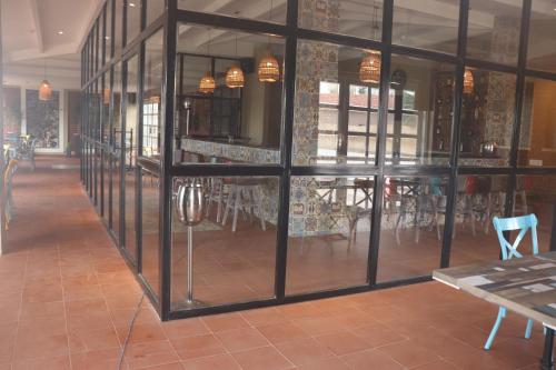 a restaurant with glass windows and tables and chairs at Swosti Chilika Resort in Kānāipur