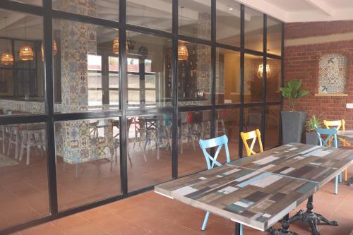a room with a table and chairs and windows at Swosti Chilika Resort in Kānāipur