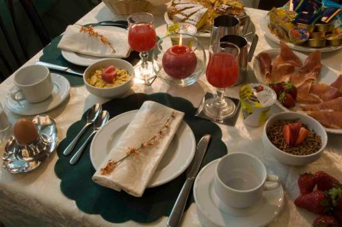 ein Tisch mit Tellern voller Speisen und Getränken in der Unterkunft Hotel Alsen in Rimini