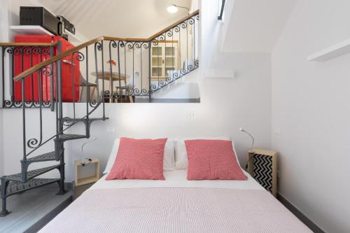una camera con un letto con due cuscini rossi di Quiet pied a terre with terrace in Borgo Pio a Roma