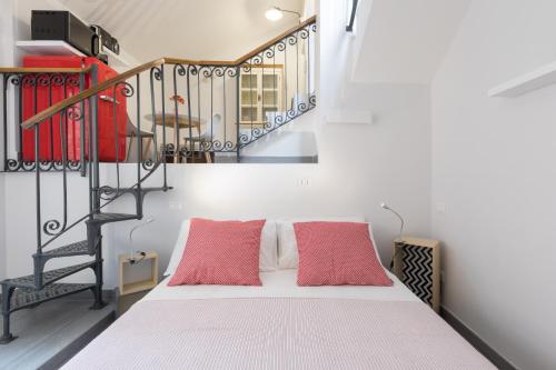 een slaapkamer met een bed met 2 rode kussens bij Quiet pied a terre with terrace in Borgo Pio in Rome