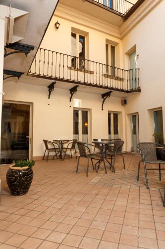 a patio with tables and chairs and a balcony at Albergo Orologio in Brescia