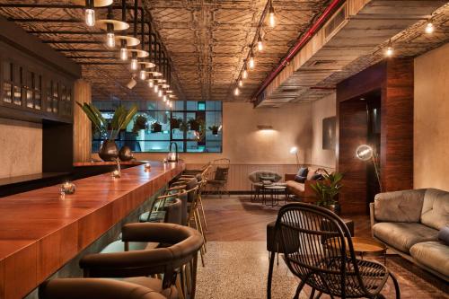a bar in a restaurant with chairs and tables at The Vera in Tel Aviv