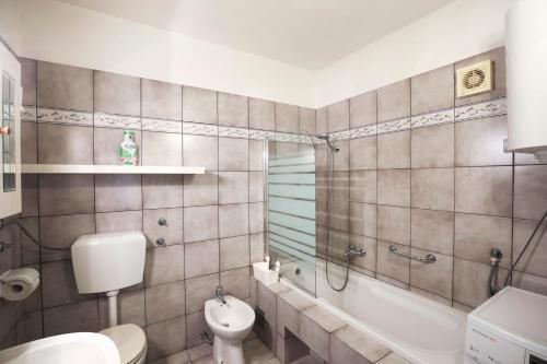 a bathroom with a toilet and a tub and a sink at Vrata Jadrana in Rijeka