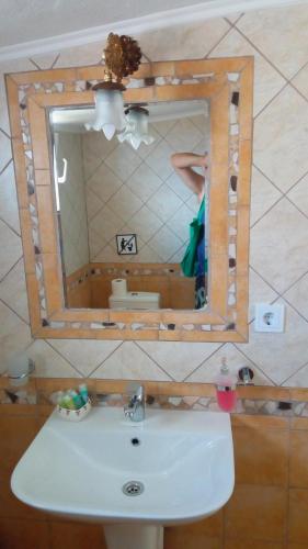 a person standing in front of a mirror over a sink at Villa Elli in Ammouliani