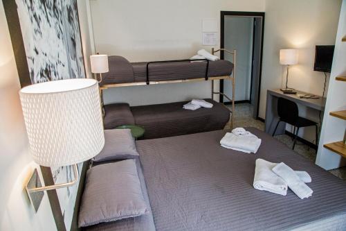 a small room with two bunk beds and a desk at Hotel Hollywood in Riccione
