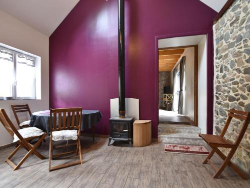 uma sala de estar com um fogão a lenha e paredes roxas em Breton stone house in Saint Gilles les Bois em Saint-Gilles-les-Bois