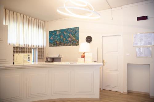 ein weißes Zimmer mit einer Theke und einem Gemälde an der Wand in der Unterkunft Hotel Atlantico in Forte dei Marmi