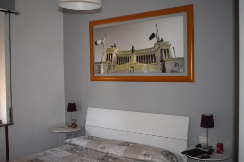 1 dormitorio con una foto de un edificio en la pared en B&B Lost in Rome, en Roma