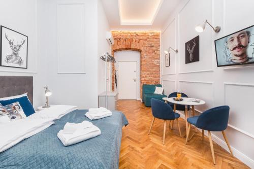 a bedroom with a bed and a table and chairs at The Old Town View in Kraków