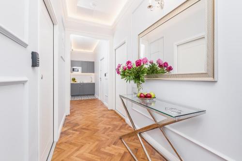 a hallway with a glass table with flowers on it at The Old Town View in Kraków