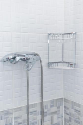 a shower with a shower head in a bathroom at Sobe Mateša in Vodice