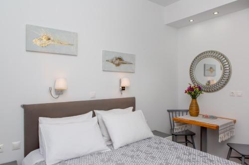 a bedroom with white walls and a bed with white pillows at La isla in Naxos Chora