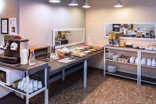 a kitchen with two tables with food on it at Hotel Catalunya Express in Tarragona