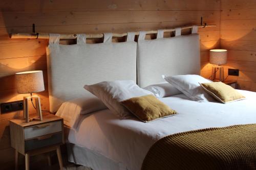 a bedroom with a large white bed with two lamps at Piedrafita Mountain in Piedrafita de Jaca