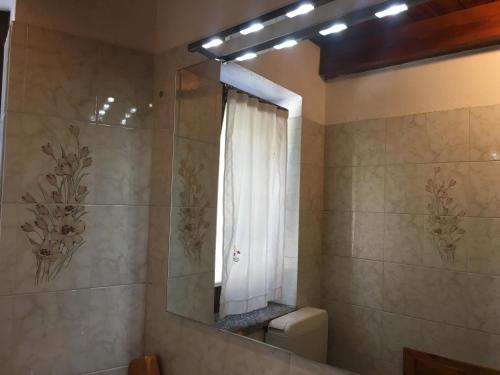 een badkamer met een spiegel, een toilet en een raam bij B&B La Vieille Meison de Pappa in Aosta