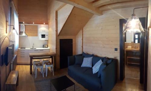 a living room with a blue couch and a kitchen at Piedrafita Mountain in Piedrafita de Jaca
