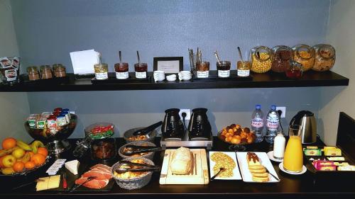 una mesa con muchos tipos diferentes de comida en ella en Astrid Hotel, en Rennes