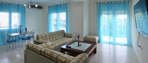 ein Wohnzimmer mit 2 Sofas und einem Tisch in der Unterkunft Kokkos Brothers in Kallithea (Chalkidiki)