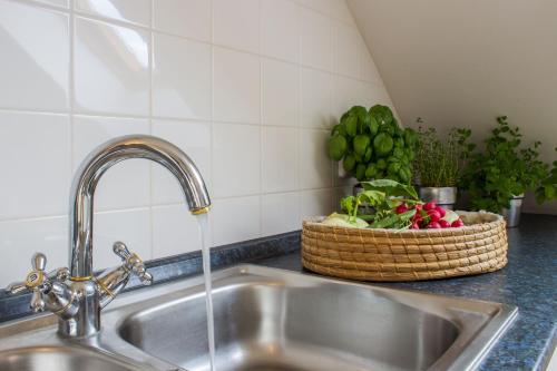 a kitchen sink with water running from a faucet at Vila Les Kralovstvi in Nemojov
