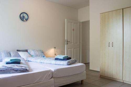 a white bed with blue pillows on it in a room at Vila Les Kralovstvi in Nemojov