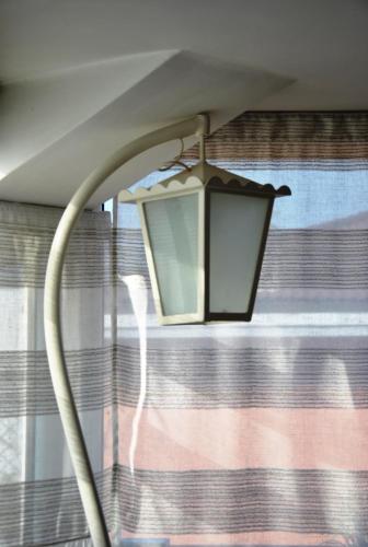 a lamp in a room with a window at La Mansarda più bella e luminosa vicino al centro! in Vicenza