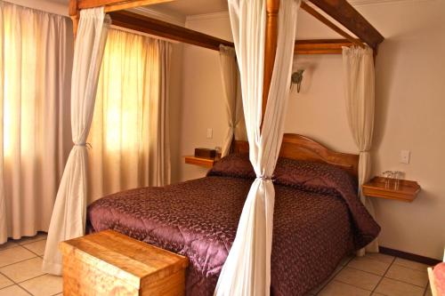 1 dormitorio con 1 cama con dosel en Red Mountain House en Clarens