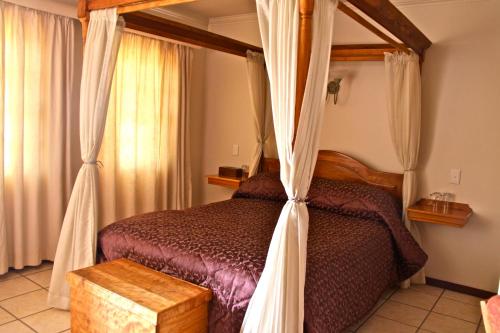 1 dormitorio con 1 cama con dosel en Red Mountain House, en Clarens