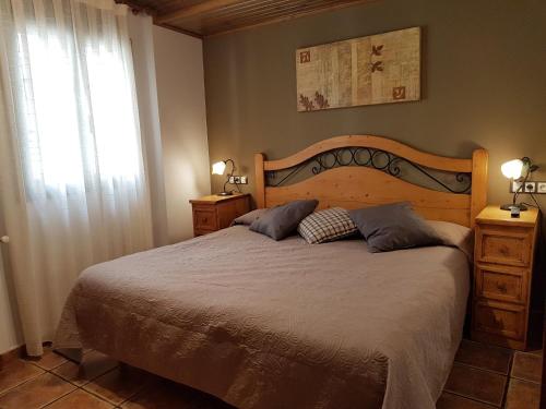 a bedroom with a large bed and a window at Apartaments Cal Noi in Camprodon