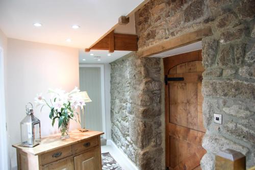 チャグフォードにあるHollyberry Barnの石壁と木製のドアが特徴の客室