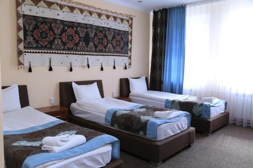 A bed or beds in a room at Khan Tengri Hotel