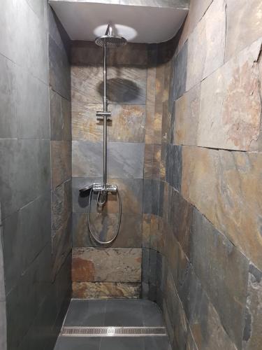 a shower in a bathroom with a stone wall at Riad Medina Mudejar in Toledo