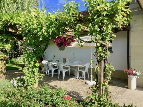 a garden with a table and chairs under a pergola at "Zur alten Schmiede", 70m2 Studio mit Kaminfeuer und Sauna in Fraubrunnen
