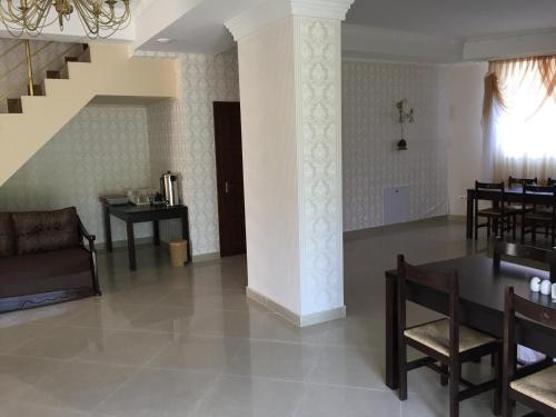 a living room with a table and chairs and a staircase at Pylypets Inn in Pilipets