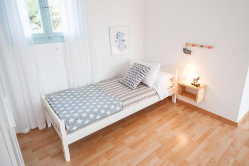 a small white bed in a room with a window at Asterias in Panteli