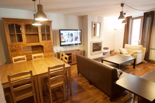 a living room with a table and a dining room at Apartaments Cal Noi in Camprodon