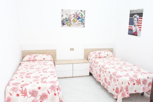 Duas camas num quarto com paredes brancas em La Fata em Balestrate
