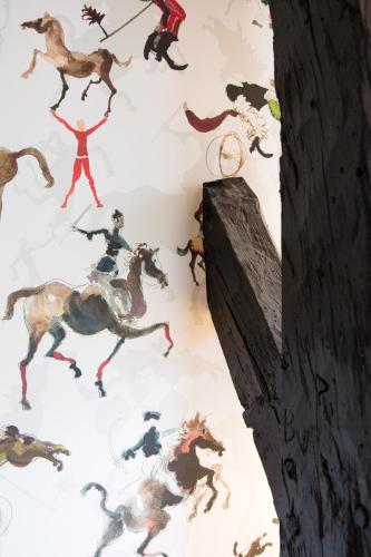 a wall with a mural of horses on a wall at Hotel Napoleonschuur in Amerongen