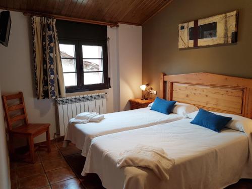 a bedroom with two beds and a window at Apartaments Cal Noi in Camprodon