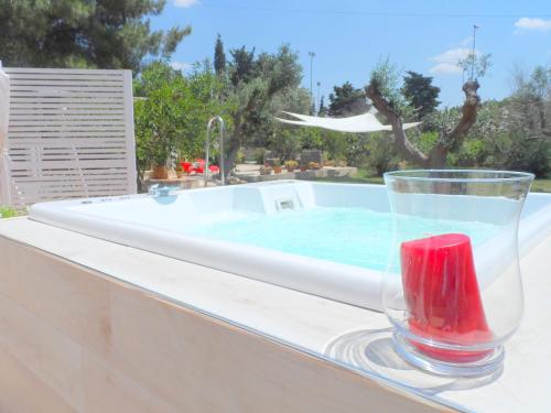 un vaso de agua sentado en una cornisa junto a una piscina en B&B Santa Venardia Gallipoli, en Gallipoli